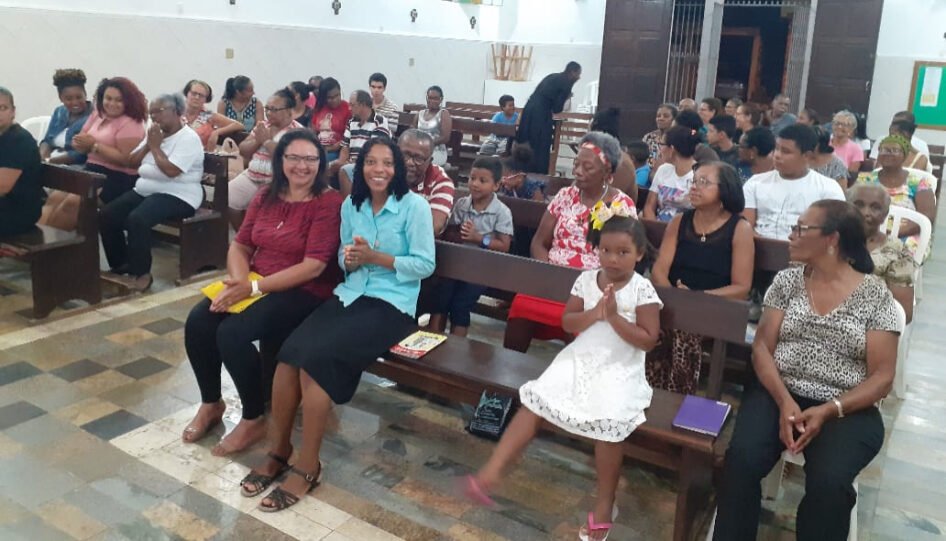 Grupo de pessoas dentro de uma igreja.