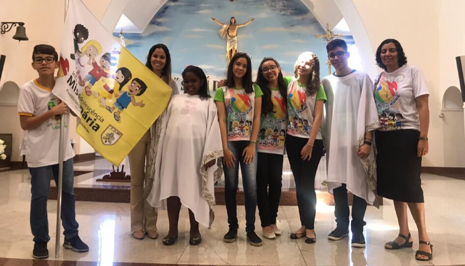 Oito jovens em uma cerimônia que acontece dentro da igreja.