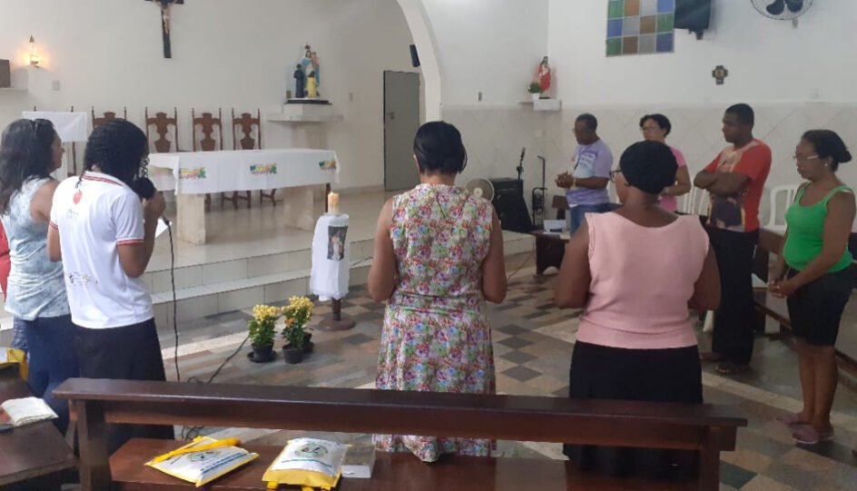 Grupo de pessoas em uma cerimônia, dentro da igreja.