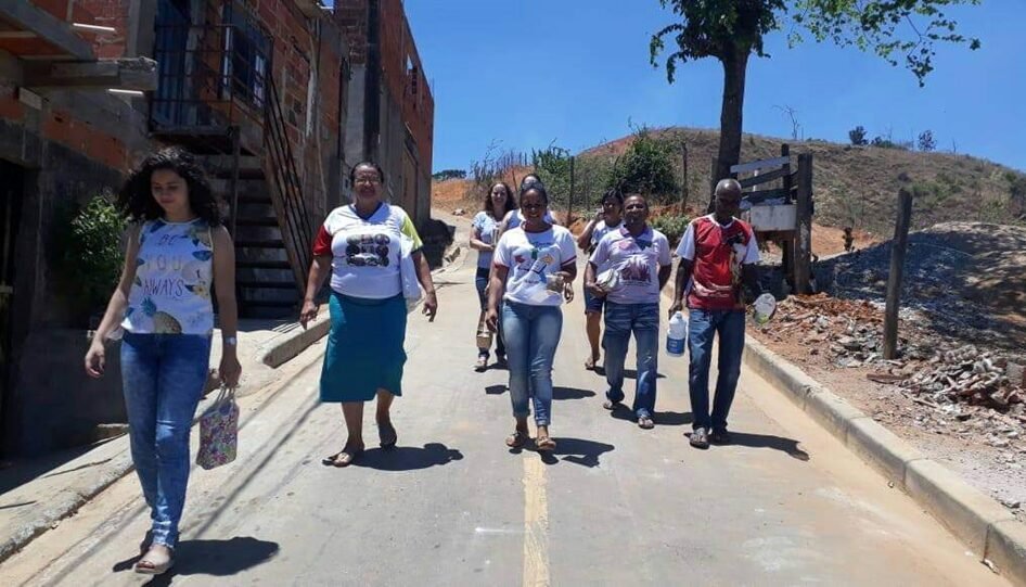 Seis mulheres e dois homens descendo uma rua.
