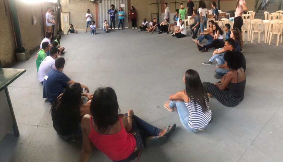 Grupo de pessoas sentadas, em roda.