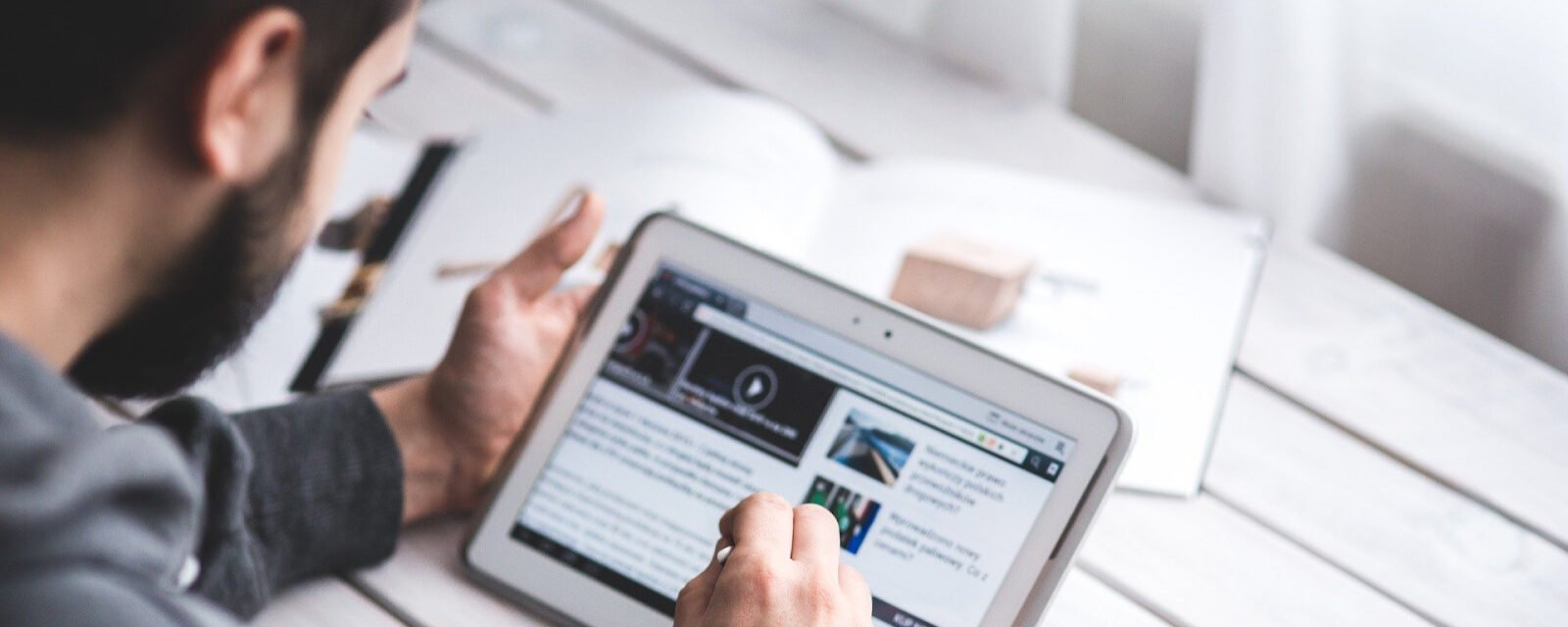 Um homem lendo notícias em um tablet.